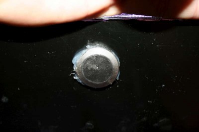 Jag borrade hål i framrutan och limmade fast magneten med silicon så att den ligger i jämnhöjd med baksidan, då sluter den helt tätt. Överblivet silicon skärs bort när det torkat.